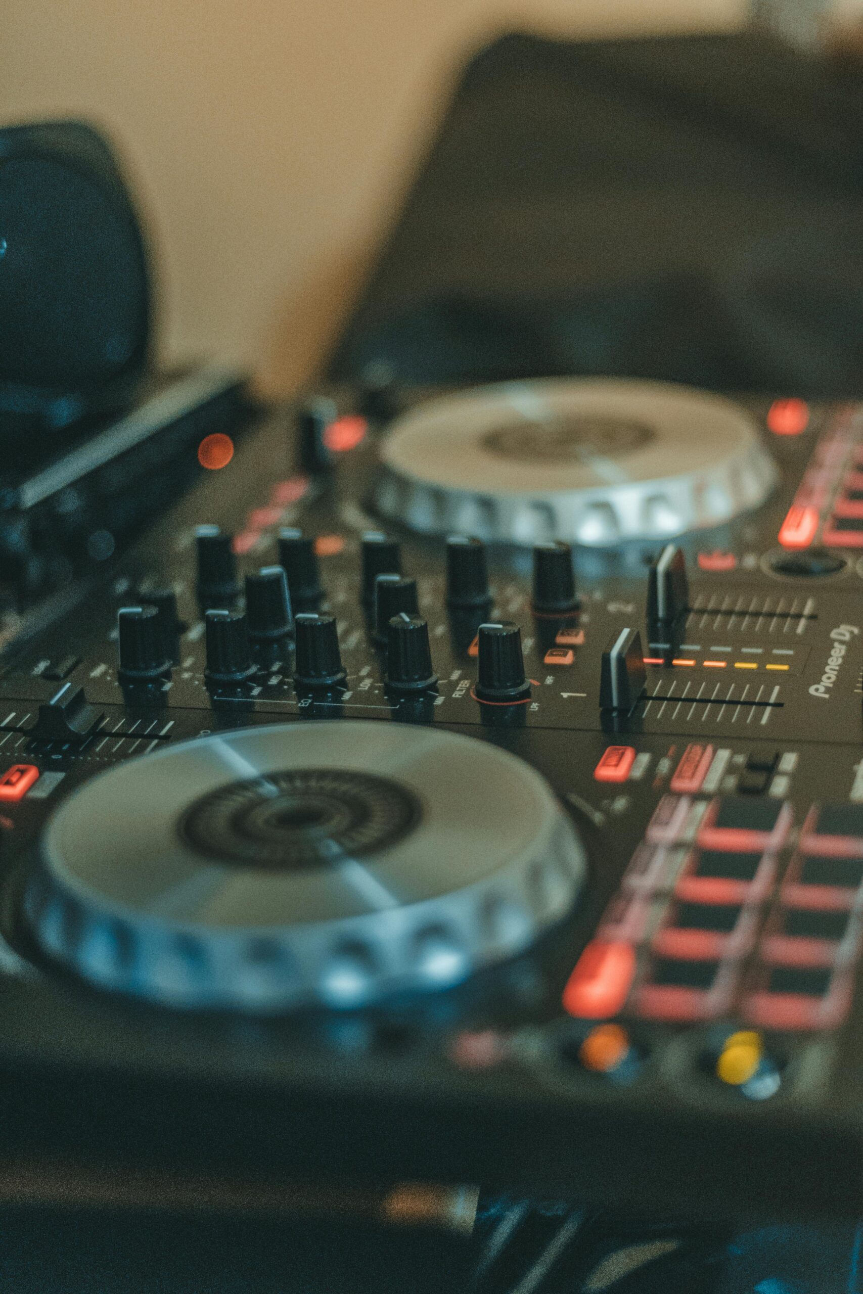 Close-up of a professional DJ mixing console featuring turntables and various controls for music production.