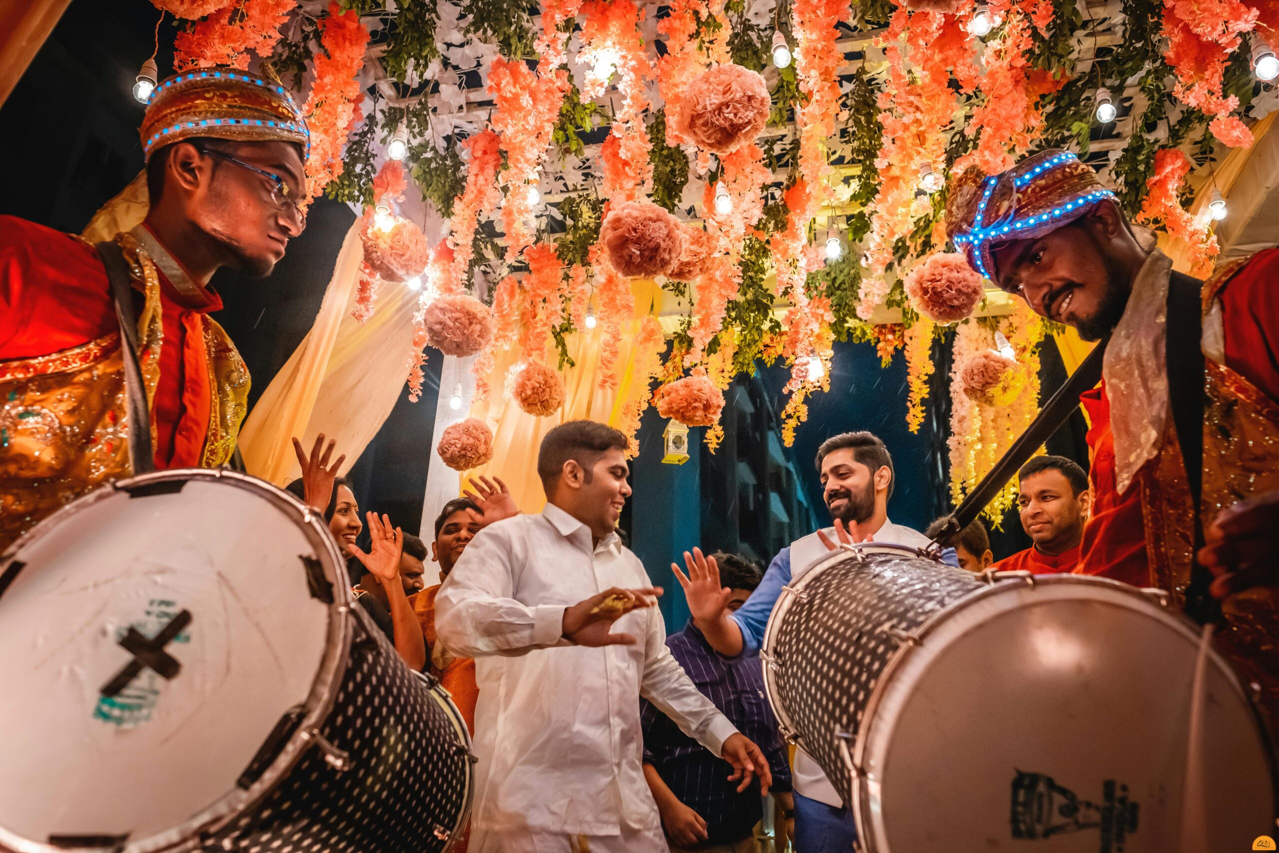 Energetic Indian wedding celebration with festive drummers and colorful decorations in Kolkata.